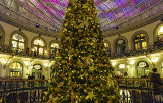 Large scale cone tree decorated with gold decorations at Leeds Corn Exchange.