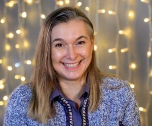 A headshot image of a Fizzco director in front of warm white curtain lights.