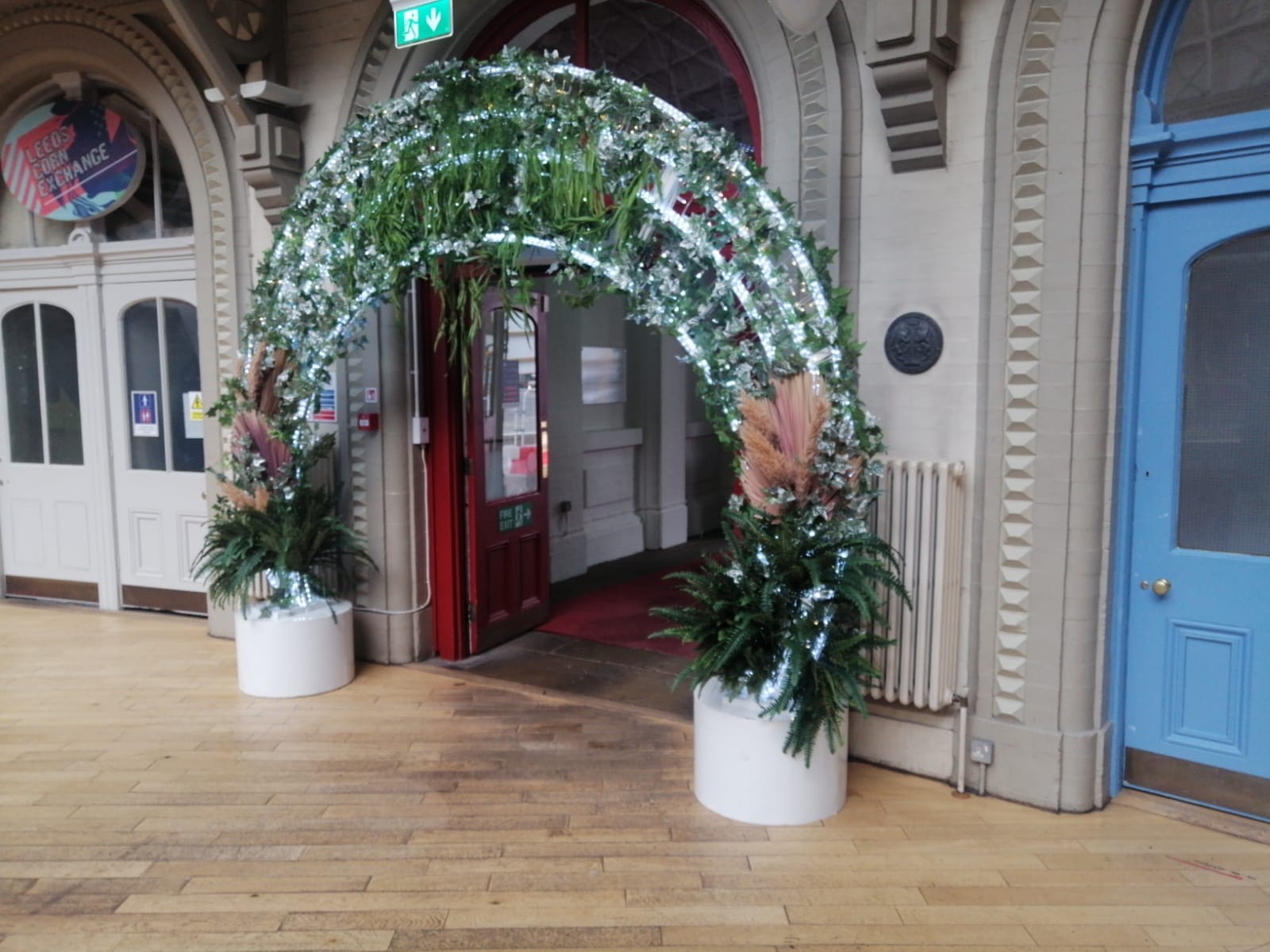 Light up greenery arch displayed outside a doorway entrance in Leeds corn exchange shopping centre.