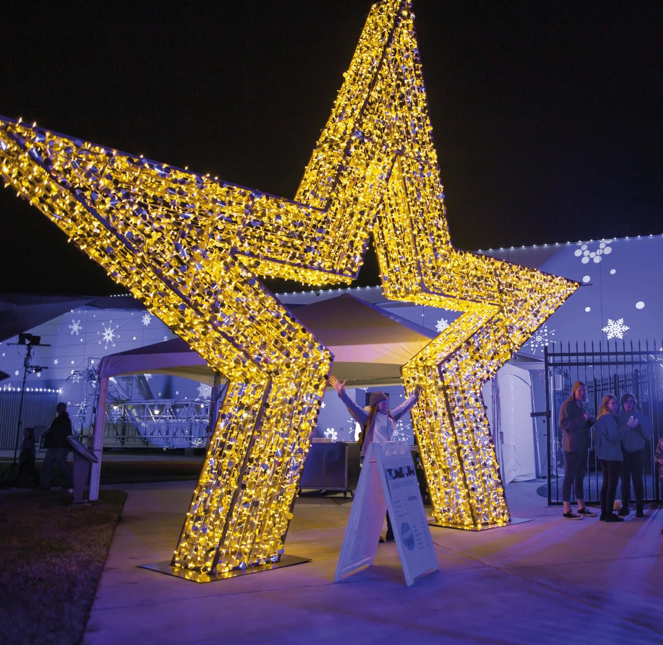 Light up gold star motif displayed outside the entrance of an outdoor event.