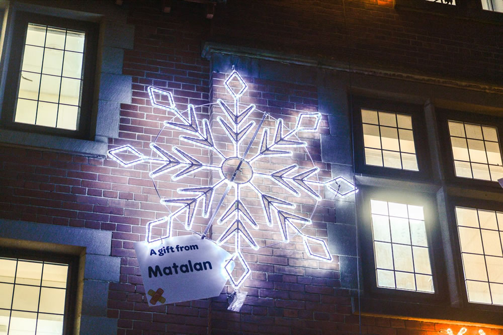 Bright white light up snowflake displayed on the outside wall of Sheffield Children's hospital.