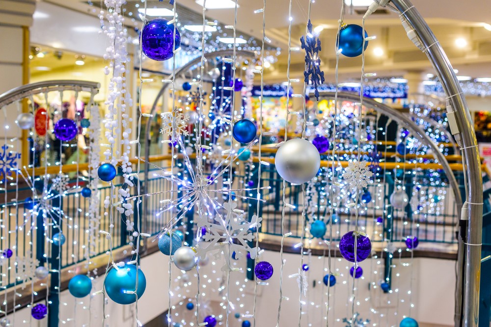 Close up of bright white curtain lights decorated with light blue, silver and dark blue baubles at Alhambra Shopping Centre.