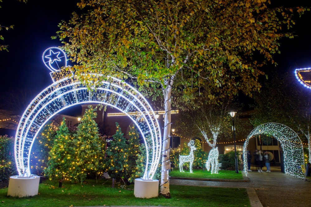 Bright white light up bauble arch, two bright white light up reindeer motifs and a bright white walk through arch displayed outside in St Marks garden in Lincoln City Centre.
