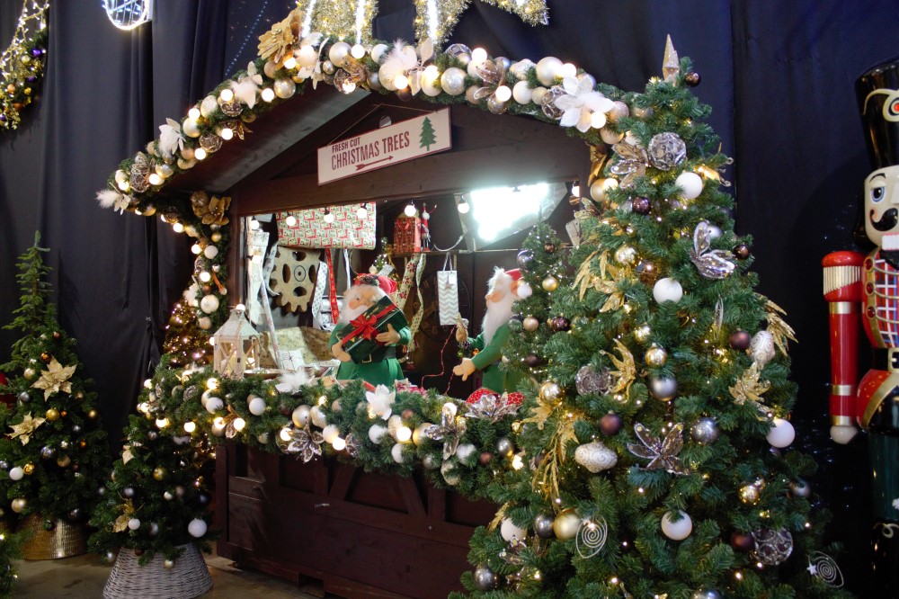 Christmas Grotto scene with artificial Christmas Trees and Wreaths with white, silver and brown baubles and foliage.