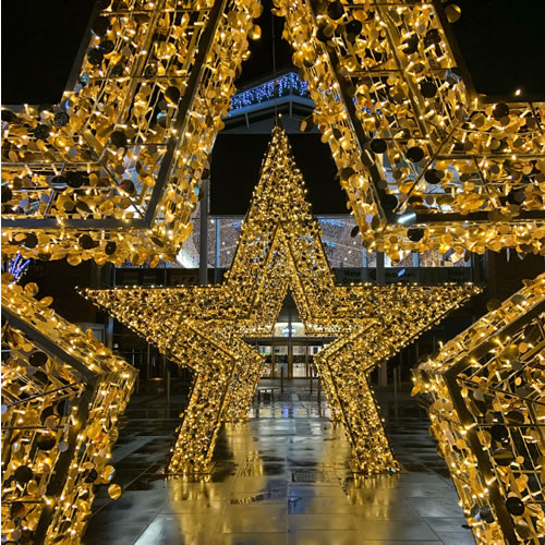 3D light-up gold star motifs featured outside a Shopping Centre as a part of a Christmas display.