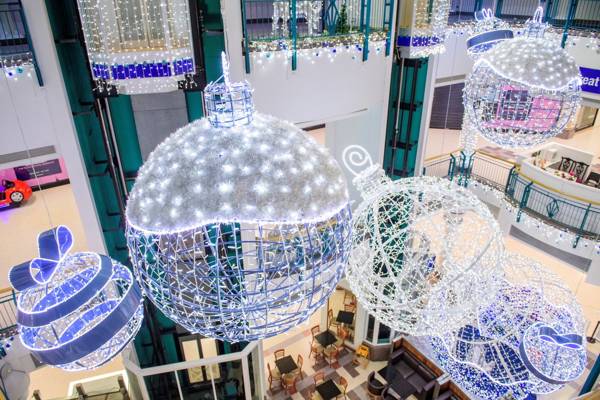 Giant 3D sphere hanging in shopping centre. Including bright white Christmas lights and blue disc garland. 